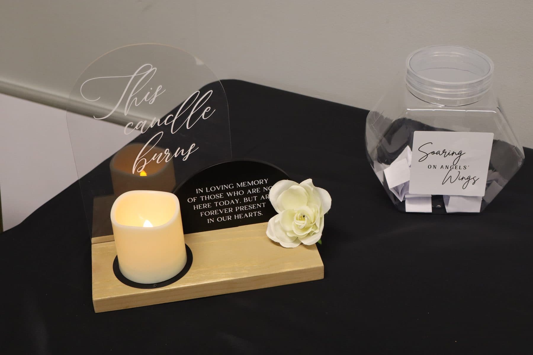 A remembrance candle with a white flower