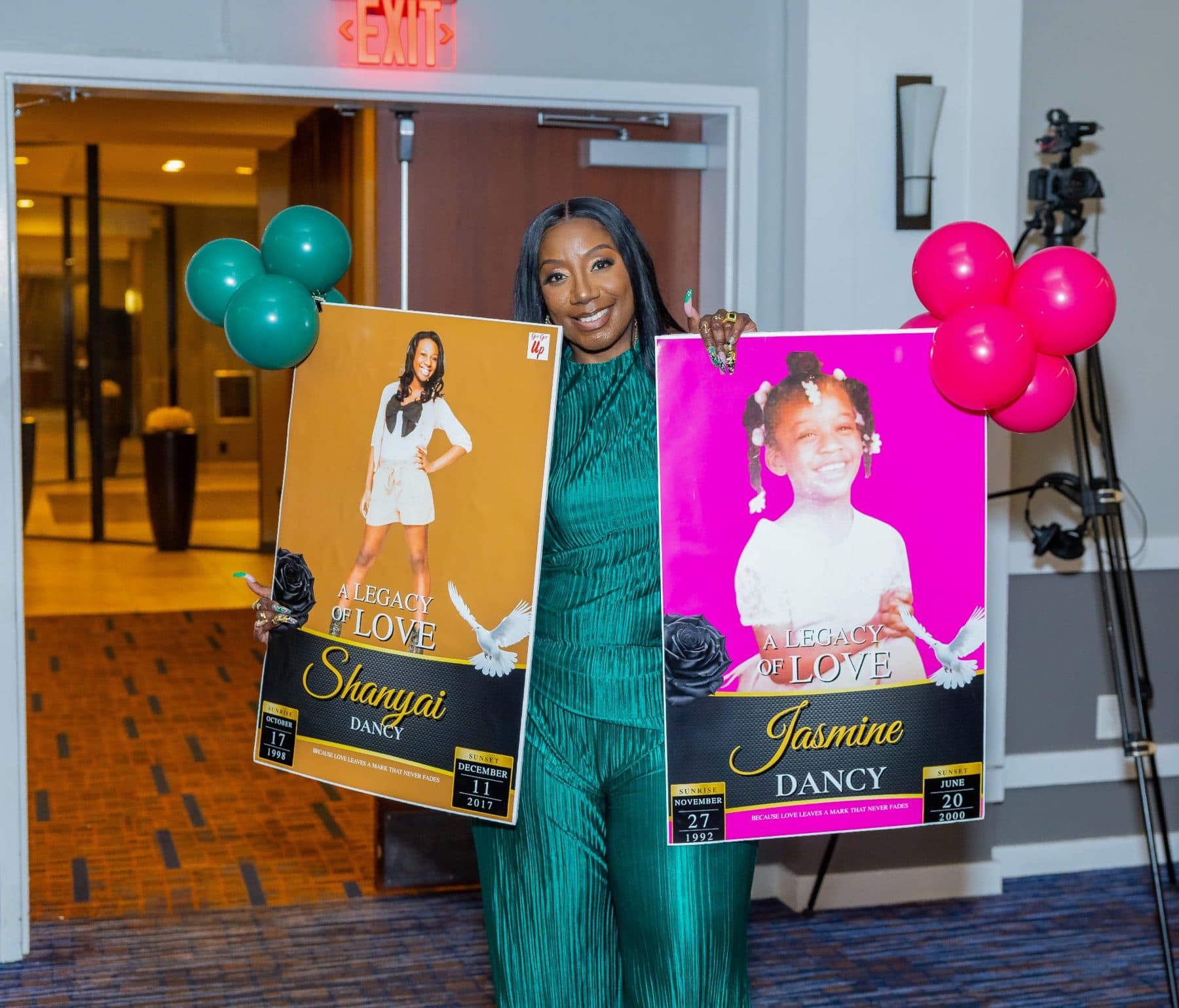 Dr. Tracy J. Dancy holding portraits of her daughters, Shanyai and Jasmine